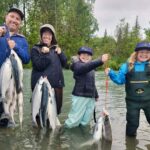 Family fishing with caught salmon.